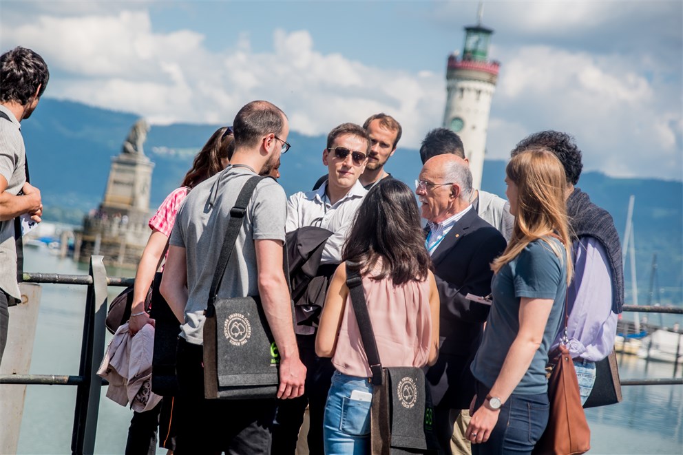 Louis Ignarro together with young scientists in front of the Lindau’s harbour entrance